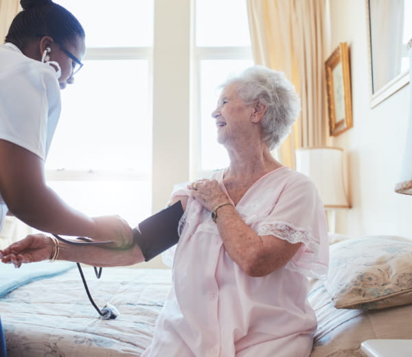 Photo of a nurse checking the blood pressure of elderly patient 